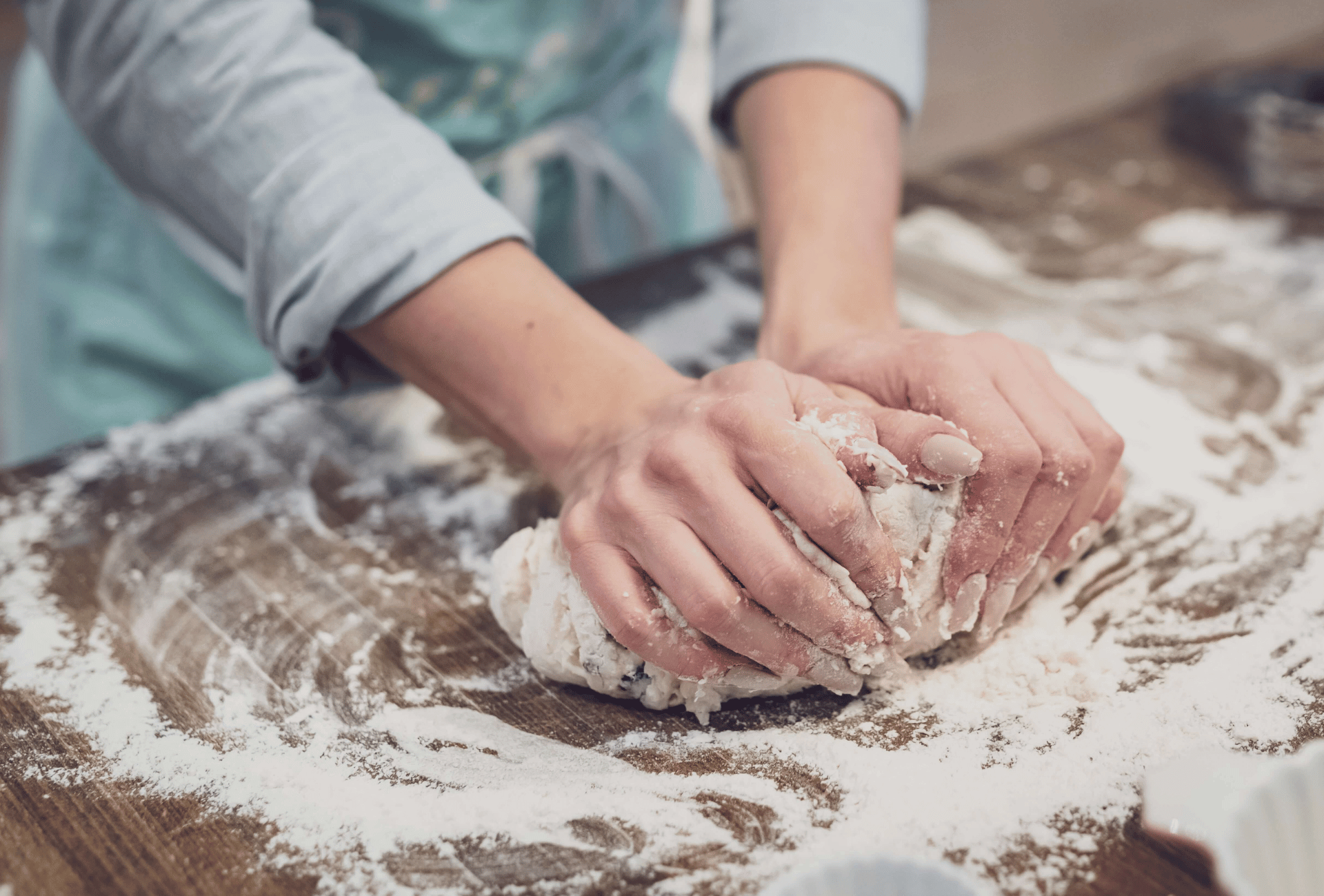 A baker kneads some dough on a counter covered in flower. This represents SMEs.